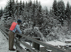 Image of a forecaster taking a river reading